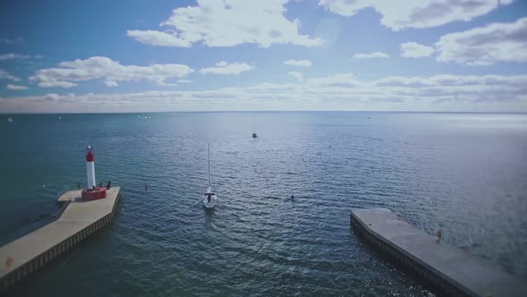 Drone flying over lake Ontario away from Oakville marina and lighthouse, Canada alt