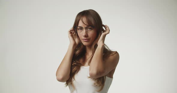 Young Woman Wearing White Making Glasses Move