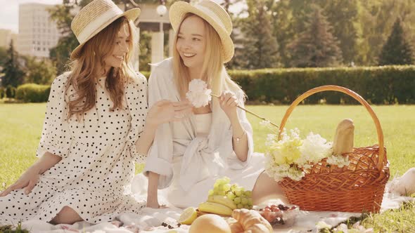 Two young beautiful hipster woman in trendy summer sundress and hats posing outdoors alt