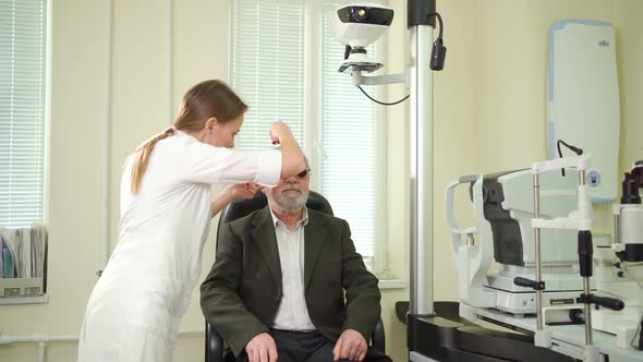 Ophthalmologist Makes Selection of Lenses Diagnoses a Elderly Man's Vision alt