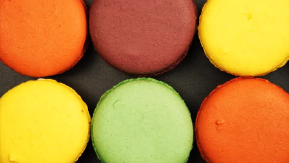 Top view of a Rows of Colorful Macaroons on a black table