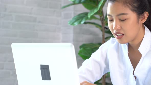Happy Friendly Asian Woman Using a Laptop and Talking Making Video Call Conference at Home alt