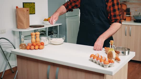 Senior Man Taking Flour From Glass Bowl alt