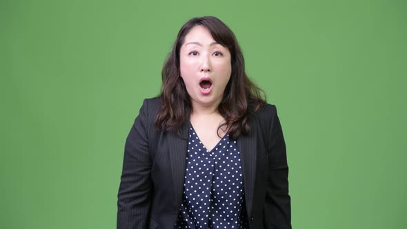Mature Beautiful Asian Businesswoman Looking Shocked alt