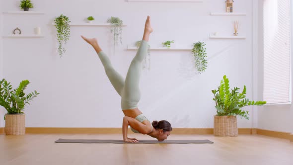 Side view of Wellness Asian woman wear green sportswear doing Yoga exercise,Yoga Chin stand pose Gan alt