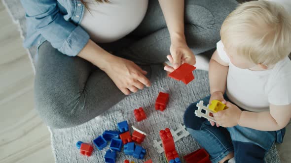 Top view video of  mother playing toy blocks with son. Shot with RED helium camera in 8K  alt