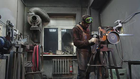A Blacksmith Sharpens a Knife in a Workshop
