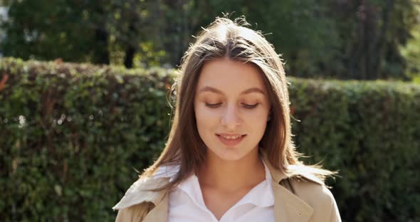 Portrait of Young Attractive Female Who Smiling and Looking at the Camera on Green Historical Urban alt