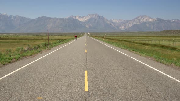 A man road biking on a scenic road. alt