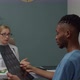 Male Patient Looking at MRI Image Questioning Female Doctor Indoors - VideoHive Item for Sale