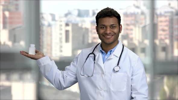 Smiling Indian Doctor Advertising Bottle of Medicine alt