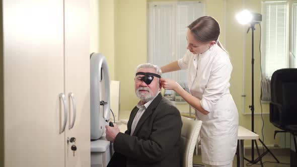 Oculist Examination of Elderly Man on Device Perimeter of Field of View alt
