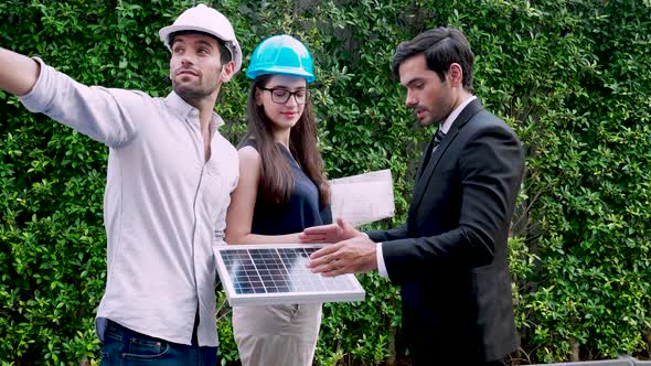 Solar power plant Engineers Team standing and discussion solar panel project together alt