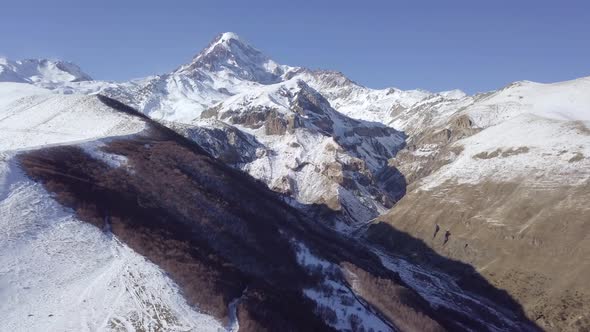 Aerial footage of georgian mountains in Kazbegi, Georgia. Drone flies between hills and dunes alt