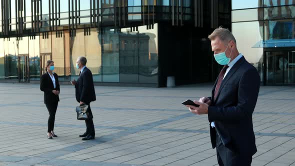 Portrait of Confident Business Man in Protective Face Masks Piking Up the Phone, Having Business