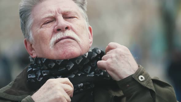 Brave Man with a Mustache in Jacket Twisting Scarf in Autumn in Slow Motion   