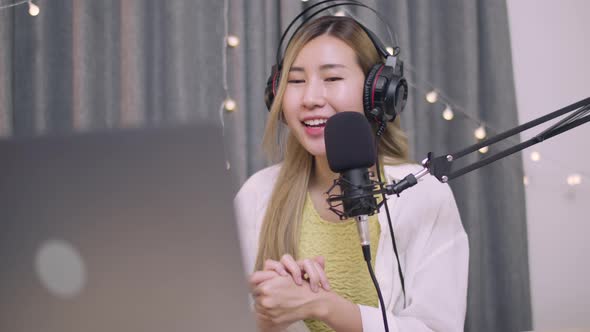 Asian woman influencer recording a vlog using podcast microphone.