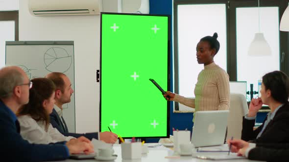 Diverse Woman Standing in Start Up Office Discussing Strategy with Green Screen Display alt