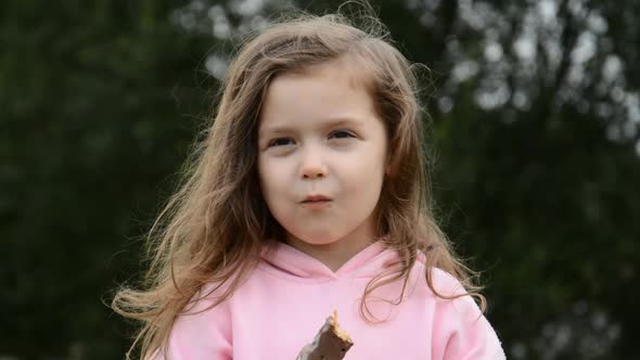Portrait of a Beautiful Little Girl Eating Chocolate alt