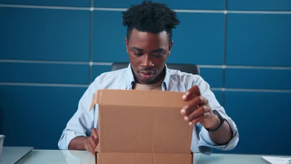 Frustrated African American Man Open Cardboard Box Receive Damaged Wrong Parcel alt