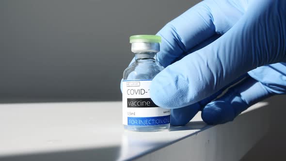 COVID19 Vaccine in Researcher Hands Doctor Puts on the Table Syringe and Bottle with Vaccine for alt
