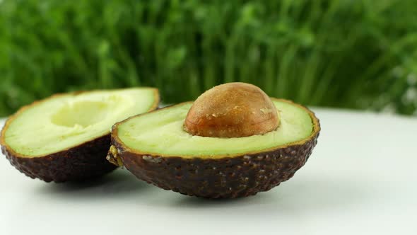 Avocado rotates on a green grass background. 4K video close-up of wholesome and healthy food alt