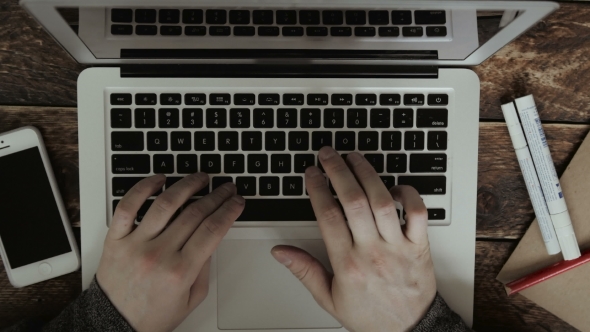 Businessman Typing On His Laptop On a Wooden Desk Table alt