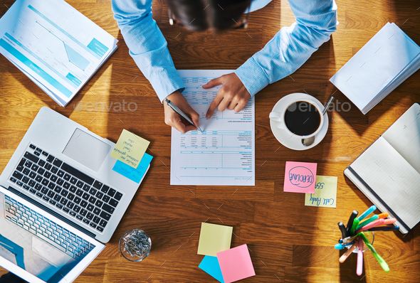 Businesswoman working on a report or questionnaire - Stock Photo - Images