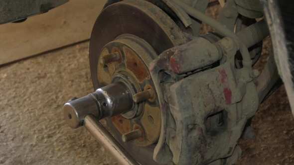 Mechanic Dismantling Brake Disk Of Car