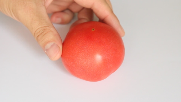Male Hands Slicing Red Tomato