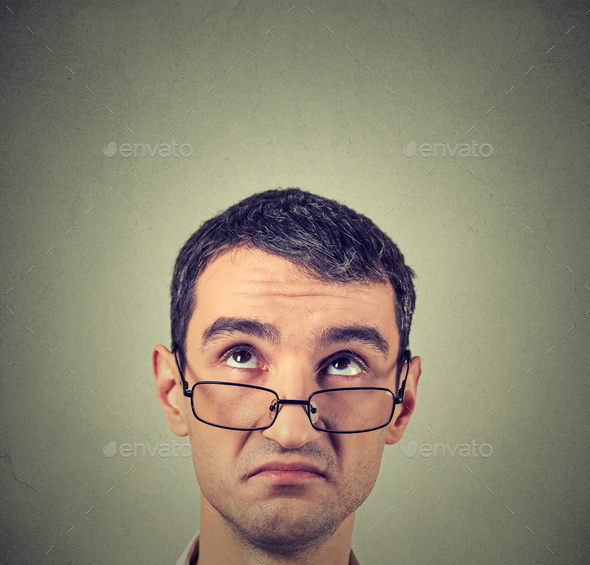 funny confused skeptical man in glasses thinking planning looking up