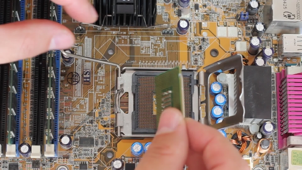 Man Pulls Out a Computer Processor From The Motherboard alt