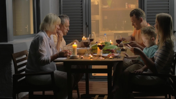 Big Family Having Meal In Late Evening alt