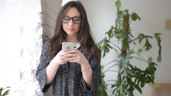 Beautiful Girl Typing Text on Smartphone alt