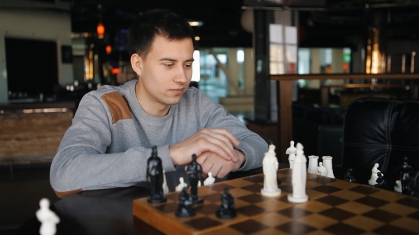 Young Man Playing Chess In The Restaurant alt