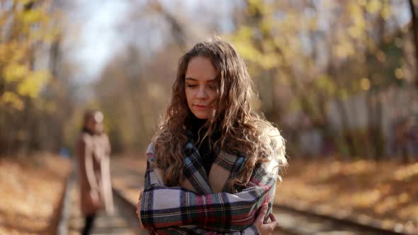Portrait of a Woman with Curly Hair and a Plaid Coat on a Sunny Day alt