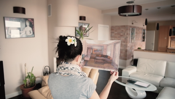 Happy Young Woman Watching a Beautiful Design Project To Make It Their Home.