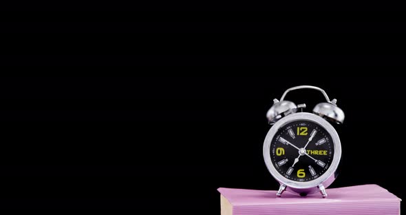 Alarm clock on book stack alt