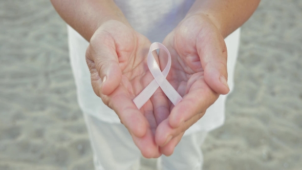Breast Cancer Awareness Ribbon In Womans Hands alt