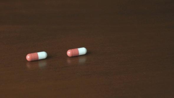 Pills In The Form Of Capsule Fall On a Table