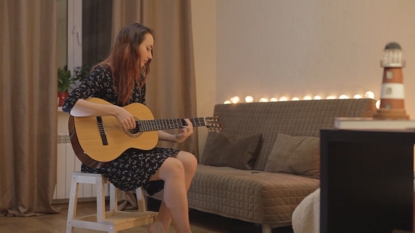 Young Girl Playing The Guitar At Home