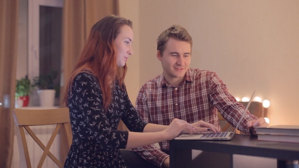 Young Couple Discussing Internet Shopping a Laptop alt