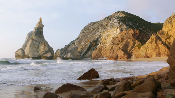 The Ocean Surf on an Empty Beach Between the Cliffs alt
