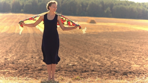 Girl on a Background of Field in a Strong Wind.