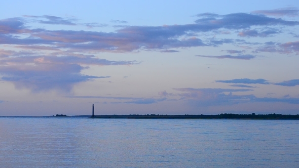 Tern Flies At Sunset With Beautiful Clouds And Lighthouse