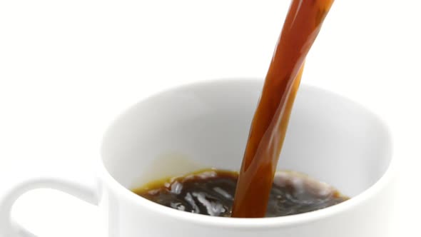 Jet of Black Hot Coffee Pouring Into Mug Slow Motion Isolated on White Backdrop