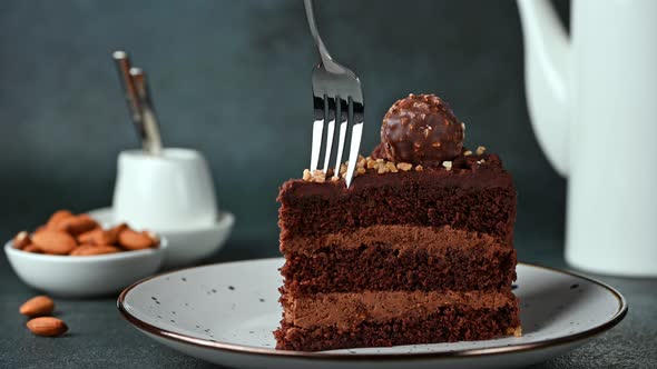 Eating chocolate cake. Taking a bite of chocolate cake with a fork. Hazelnut cake. Coffee cake.