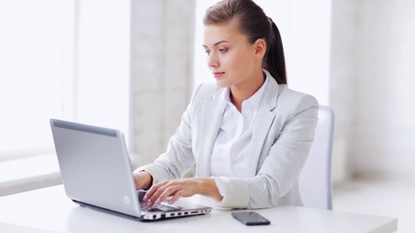 Woman With Laptop Talking On Smartphone At Office 61