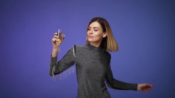 Woman in Silver Shirt Holding Glass of Champagne and Dancing