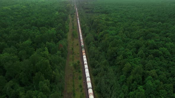 The Train Transports Tanks of Crude Oil Among Virgin Ecological Green Forests